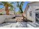 A backyard featuring a concrete patio, block wall and lush green palm trees at 10026 Mystic Dance St, Las Vegas, NV 89183