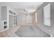 Neutral living room featuring tile and carpet flooring, built-in shelving, and large windows at 10026 Mystic Dance St, Las Vegas, NV 89183