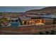 Aerial view of backyard featuring a pool, lounge area, and solar panels at dusk at 10096 Amethyst Hills St, Las Vegas, NV 89148