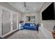Cozy bedroom features a comfortable blue couch, entertainment center, and plush shag carpet at 10096 Amethyst Hills St, Las Vegas, NV 89148