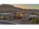Stylish home with manicured landscaping, a welcoming entrance, and stunning mountain views at sunset at 10096 Amethyst Hills St, Las Vegas, NV 89148