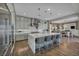 Open-concept kitchen with waterfall island, stainless appliances, and pendant lighting at 10096 Amethyst Hills St, Las Vegas, NV 89148