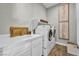 Clean laundry room featuring a sink, countertop, white cabinets, and a modern washer and dryer at 10096 Amethyst Hills St, Las Vegas, NV 89148