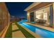 A stunning backyard features a sparkling pool, waterfall feature, and adjacent bedroom with sliding doors at 10096 Amethyst Hills St, Las Vegas, NV 89148