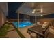 Relaxing backyard with a pool, waterfall feature, lounge area, and city views in the background at 10096 Amethyst Hills St, Las Vegas, NV 89148