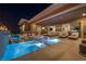 A luxurious outdoor living space features a sparkling pool, hot tub, outdoor kitchen, and lounge seating at 10096 Amethyst Hills St, Las Vegas, NV 89148