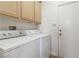 Bright utility room with washer, dryer, cabinets, and access to the outside at 10720 Sprucedale Ave, Las Vegas, NV 89144