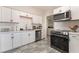 Modern kitchen with white cabinets, stainless steel appliances, and a sleek black oven range at 1216 Oahu St, Las Vegas, NV 89104