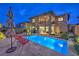 Backyard featuring a pool, manicured landscaping, patio area, and a view of the home's exterior at 12356 Grey Dunes Ave, Las Vegas, NV 89138