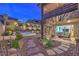 Backyard featuring professional landscaping, stone pathways, modern patio area, and a view of the home's exterior at 12356 Grey Dunes Ave, Las Vegas, NV 89138