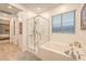 Bright bathroom featuring a tub and separate shower with a window at 12356 Grey Dunes Ave, Las Vegas, NV 89138