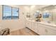 Bright bathroom with double sinks, white cabinets and large mirror over new vanity at 12356 Grey Dunes Ave, Las Vegas, NV 89138