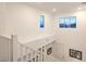 Upstairs landing with white railings and a view of the foyer with transom windows at 12356 Grey Dunes Ave, Las Vegas, NV 89138