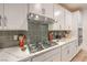 Close-up of kitchen showcasing a gas cooktop, quartz countertops, and stylish backsplash at 12356 Grey Dunes Ave, Las Vegas, NV 89138