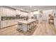 Modern kitchen with white cabinets, a large island with seating, and stainless steel appliances at 12356 Grey Dunes Ave, Las Vegas, NV 89138