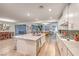 Open-concept kitchen with island, stainless appliances, and adjacent dining and living spaces at 12356 Grey Dunes Ave, Las Vegas, NV 89138
