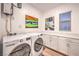 Laundry room features front loading washer, dryer and built-in cabinets at 12356 Grey Dunes Ave, Las Vegas, NV 89138