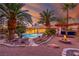Backyard oasis features a sparkling pool, fire pit, covered bar, and mature palm trees at 1561 Doran Dr, Las Vegas, NV 89123