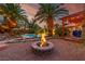 Relaxing outdoor space with a cozy fire pit, mature palms, and a backyard pool at 1561 Doran Dr, Las Vegas, NV 89123