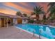 Enjoy a tranquil backyard with a refreshing pool, mature palm trees, and a covered patio at 1561 Doran Dr, Las Vegas, NV 89123