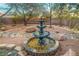 A multi-tiered water fountain surrounded by desert landscaping creating a serene backyard focal point at 1561 Doran Dr, Las Vegas, NV 89123