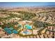 A comprehensive aerial view of the community featuring a pool, tennis courts, green areas, and residential neighborhoods at 201 White Mule Ave, Las Vegas, NV 89148