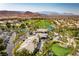 Stunning aerial view of a golf course community with lush landscaping, a clubhouse, and mountain views at 201 White Mule Ave, Las Vegas, NV 89148