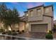 Beautiful two-story home featuring manicured landscaping, a brick driveway, and a welcoming arched entryway at 201 White Mule Ave, Las Vegas, NV 89148