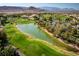 Picturesque aerial view of lush golf course, a tranquil lake, and swaying palm trees in a luxury community at 201 White Mule Ave, Las Vegas, NV 89148