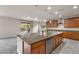 Kitchen features granite countertops, center island with sink, stainless steel appliances and view to patio at 201 White Mule Ave, Las Vegas, NV 89148