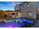 Back exterior of house featuring covered patio with outdoor kitchen and beautiful pool with inset lighting and spa at 201 White Mule Ave, Las Vegas, NV 89148