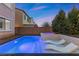 A backyard pool and spa are beautifully lit with a tanning deck and privacy wall at 201 White Mule Ave, Las Vegas, NV 89148