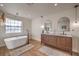 Bright bathroom featuring a soaking tub, double sink vanity, and natural light at 210 E Longacres Dr, Henderson, NV 89015