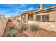 Home's backyard featuring desert landscaping, a covered patio, and block wall fence for added privacy at 213 N Cimarron Rd, Las Vegas, NV 89145