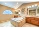 A sunburst accent piece hangs over the large garden tub in the main bathroom at 213 N Cimarron Rd, Las Vegas, NV 89145