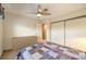 This bedroom features a window, a ceiling fan, and closet with sliding doors at 213 N Cimarron Rd, Las Vegas, NV 89145