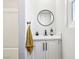 Bright bathroom featuring a round mirror, white cabinets, and a sink at 2205 Santa Clara Dr, Las Vegas, NV 89104