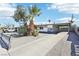 Single-story home has desert landscaping with palm trees and covered parking on a sunny day at 2205 Santa Clara Dr, Las Vegas, NV 89104