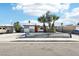 A single-story home with a gray and white checkered paint design and desert landscaping in front at 2205 Santa Clara Dr, Las Vegas, NV 89104