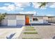 Cozy single-story home with checkered paint design, orange front door and desert landscaping with rocks at 2205 Santa Clara Dr, Las Vegas, NV 89104