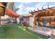 Backyard showcasing a covered patio, artificial turf, and an additional storage shed at 2245 Saint Paul Way, Las Vegas, NV 89104