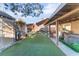 Backyard featuring artificial turf, a covered patio, an outdoor kitchen, and a hot tub at 2245 Saint Paul Way, Las Vegas, NV 89104