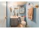 Well-lit half-bathroom with light blue walls and a vanity with a mirror and towel rack at 2245 Saint Paul Way, Las Vegas, NV 89104