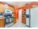 Traditional kitchen featuring oak cabinets, white appliances, tile backsplash, and white tiled floors at 2245 Saint Paul Way, Las Vegas, NV 89104