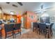Open-concept kitchen and dining area with oak cabinets, white appliances, breakfast bar, and tile flooring at 2245 Saint Paul Way, Las Vegas, NV 89104