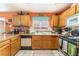 View of the kitchen with orange walls, a full set of appliances, and oak cabinets at 2245 Saint Paul Way, Las Vegas, NV 89104