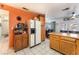 Cozy kitchen features oak cabinets, white appliances, white tiled floors, and breakfast bar with backyard views at 2245 Saint Paul Way, Las Vegas, NV 89104