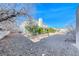 Large backyard with open space, a few trees, and a glimpse of the house behind them at 241 E Country Club Dr, Henderson, NV 89015