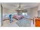 Bright bedroom featuring neutral carpet, a ceiling fan, and a large window with natural light at 241 E Country Club Dr, Henderson, NV 89015