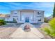Charming two-story home featuring a light gray exterior, concrete perimeter, and a well-maintained front yard at 241 E Country Club Dr, Henderson, NV 89015